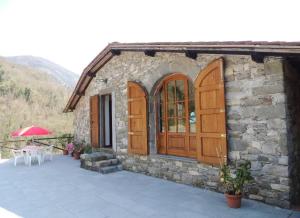 a stone building with wooden doors and a patio at Casa Lavanda in Pescaglia
