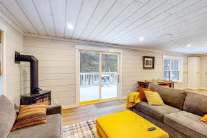 a living room with a couch and a wood stove at Grouse's Nest in Rangeley