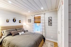 a bedroom with a bed with white walls and a window at Grouse's Nest in Rangeley
