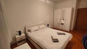 a bedroom with a white bed with towels on it at Apartman SUNCE in Trebinje