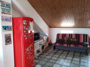 Zimmer mit einem roten Kühlschrank und einem Sofa in der Unterkunft El Akito, Huéscar in Huéscar