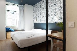 - une chambre avec un lit, une table et une fenêtre dans l'établissement The Central House Lisbon Baixa, à Lisbonne