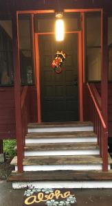 a front door of a house with a wreath on the door at The Hawaii Red House Apartment Private in Keaau