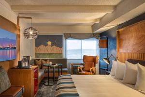 Habitación de hotel con cama y silla en Aviator Hotel Anchorage, en Anchorage