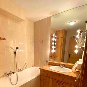 a bathroom with a sink and a tub and a mirror at Verbier centre, 2 chambres proche de tout. in Verbier