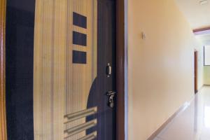 a wooden door with a shadow of a person at OYO Hotel Kanyaratna And Lodging in Chas