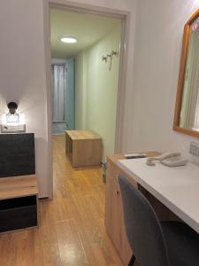 a room with a desk and a room with a mirror at Hotel Nefeli in Volos