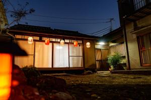 una casa con luces delante de ella por la noche en LARGE HOUSE Lodging Hidamari, en Tokio