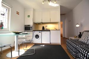 cocina y sala de estar con lavadora y secadora. en pdl.city studio, en Ponta Delgada