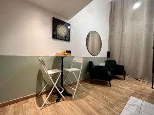 une chambre avec des chaises, une table et un miroir dans l'établissement Suite Titouan, à Villeurbanne
