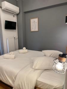 a large white bed with two towels on it at Hotel Nefeli in Volos