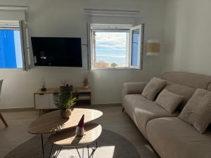 ein Wohnzimmer mit Sofa und Fernseher in der Unterkunft Casita La Basseta d’ Oli in Villajoyosa + 22 Fotos