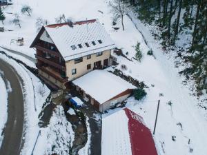 una casa coperta di neve accanto a una strada di Ferienwohnungen Lioba Huber a Bad Peterstal-Griesbach