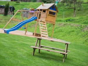 a wooden play set with a slide and a playground at Ferienwohnungen Huber in Bad Peterstal-Griesbach