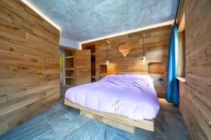 a bedroom with a bed in a wooden wall at Tana del picchio Nero in Falcade
