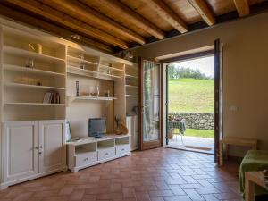 ein Wohnzimmer mit einem TV und einer Glasschiebetür in der Unterkunft Agriturismo Il Pianetto in Verona