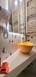 a bathroom sink with a yellow bowl on a counter at Hotel Nefeli in Volos