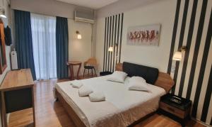 a bedroom with a bed with pillows on it at Hotel Nefeli in Volos