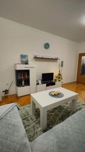 Una sala de estar con una mesa blanca y un sofá. en Apartman Sunce, en Trebinje
