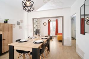 a dining room and living room with a table and chairs at Maison 2 chambres, jardin in Rethel +8 photos