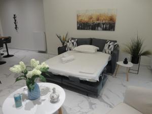 uma sala de estar com uma cama e um sofá em Athenian Center Athens Koukaki em Atenas
