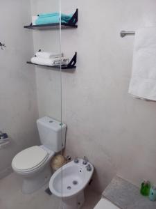 een witte badkamer met een toilet en een wastafel bij Apart Retiro. Ubicación Ideal. in Buenos Aires