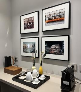 une table avec des photos accrochées à un mur dans l'établissement My Milano Charming & Luxury Rooms, à Milan