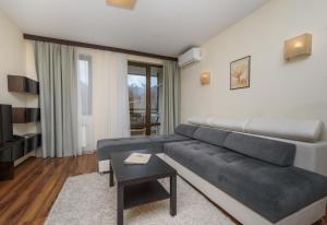 a living room with a couch and a table at St George Ski & Holiday - Half Board & All Inclusive in Bansko