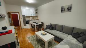 una sala de estar con un sofá y una mesa en Apartman Sunce, en Trebinje