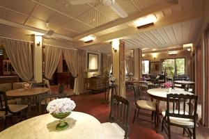 a restaurant with tables and chairs and flowers on them at Burasari Heritage Luang Prabang in Luang Prabang