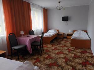 ヴロツワフにあるAGRO obiekt hotelowyのテーブルとベッド2台が備わるホテルルームです。
