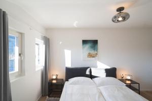 - une chambre blanche avec 2 lits et 2 fenêtres dans l'établissement LUXE VISTA City Apartment Algund, à Lagundo