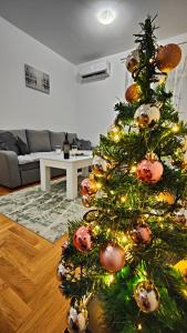 Un árbol de Navidad con adornos en la sala de estar en Apartman Sunce, en Trebinje