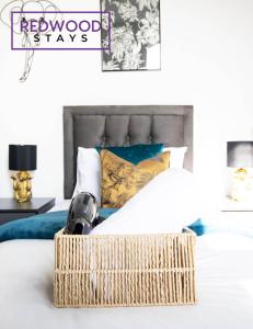 a bedroom with a bed with a wicker basket on it at Modern 1 Bed 1 Bath Apartment for Corporates & Contractors, Free Parking, Wi-Fi & Netflix By Redwood Stays in Farnborough