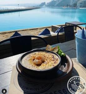 un plato de comida en una mesa con vistas al agua en Precioso San Alfonso del Mar, en Algarrobo