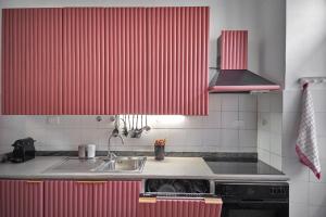 a kitchen with red striped walls and a sink at La casa fra la storia e il mare in Imperia