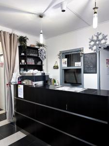 a restaurant with a black counter and a chalkboard at Malom Panzió in Kiskunfélegyháza