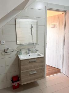 a bathroom with a sink and a mirror at Malom Panzió in Kiskunfélegyháza