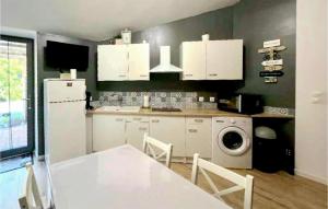 eine Küche mit weißen Schränken und einer Waschmaschine in der Unterkunft Nice Home In Coulon With Wi-fi in Coulon