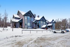 Jay Peak Village Home 375 في Jay: منزل كبير مع شاحنة متوقفة في الثلج