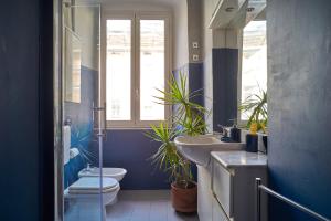 a bathroom with two sinks and a toilet and a window at La casa fra la storia e il mare in Imperia