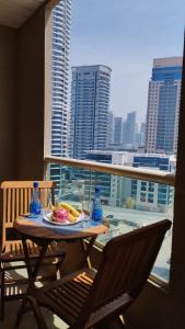 a table and chairs on a balcony with a view of a city at Marina View Manchester tower in Dubai