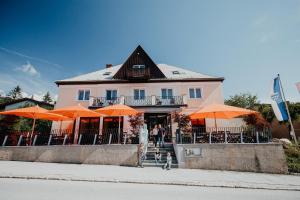 塞默靈的住宿－Der Löffler am Semmering Bed&Breakfast，一座粉红色的建筑,前面有橙色的伞