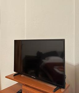 una TV a schermo piatto seduta su un supporto in legno di Nikos's apartment a Taxiarchis