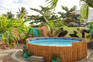 a large pool in a yard with palm trees at Back to the Beach Hostel - Pipa in Pipa