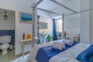 1 dormitorio con cama, aseo y lavamanos en Château le Beylon - Chambres d'hôtes en Montmaur