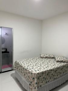 um quarto branco com uma cama e um espelho em Apartamento 3 Suítes 200mt Axé Moi até 08 pessoas em Porto Seguro