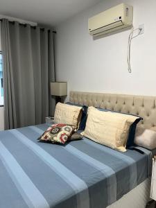 um quarto com uma cama com um edredão azul e uma ventoinha em Apartamento 3 Suítes 200mt Axé Moi até 08 pessoas em Porto Seguro