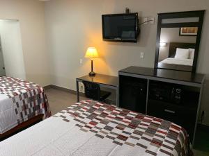 a hotel room with two beds and a mirror at Red Roof Inn Copiague in Copiague