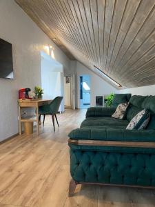 ein Wohnzimmer mit einem grünen Sofa und einem Tisch in der Unterkunft Silvan Villa - Apart in Sighişoara